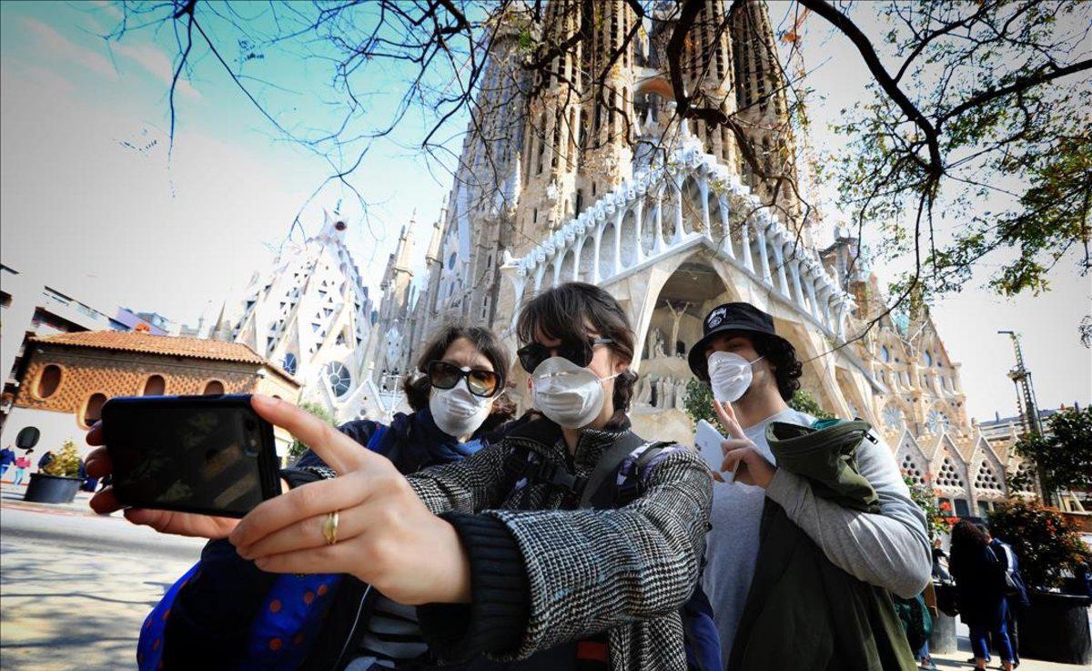 turistas-con-mascarilla-junto-sagrada-familia-1584097235898